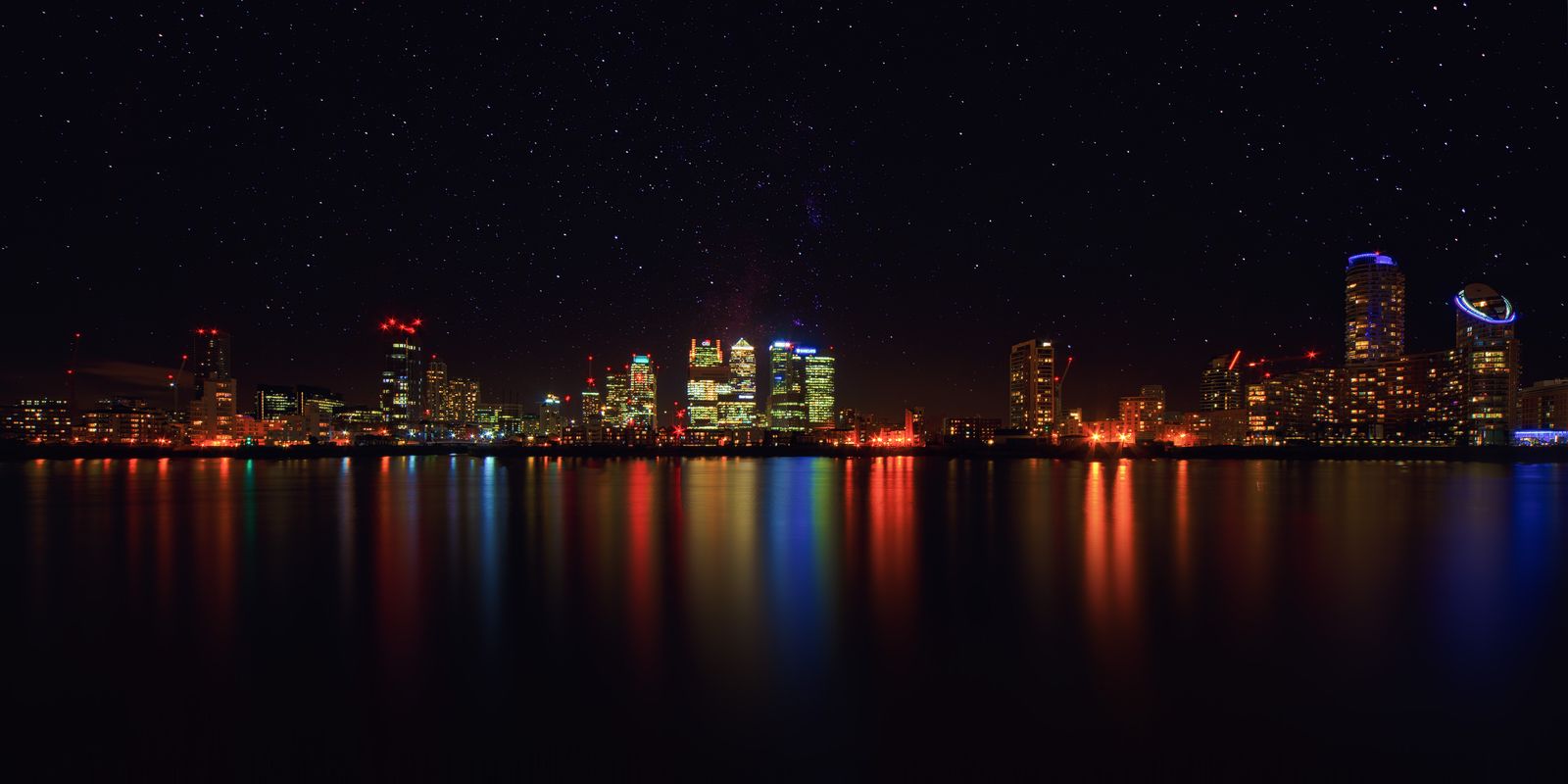 Skyline of a Modern City with Illuminated Buildings at Night — Check-in lines move faster when your documents are on your phone.