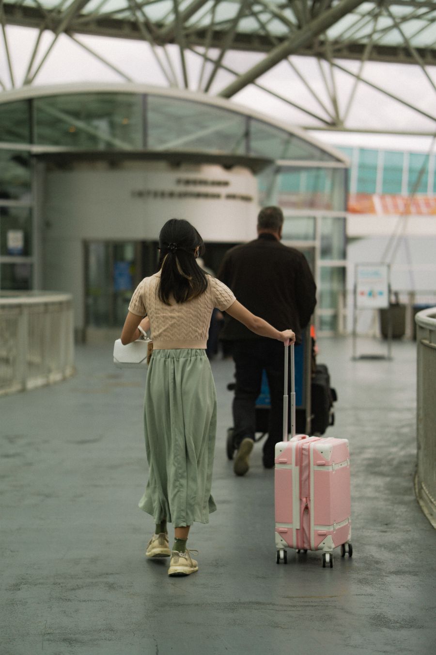 woman in brown t shirt pushing her pink luggage and man in black long sleeves pushing trolley — My Active eSIMs: answers first, never a signup wall.