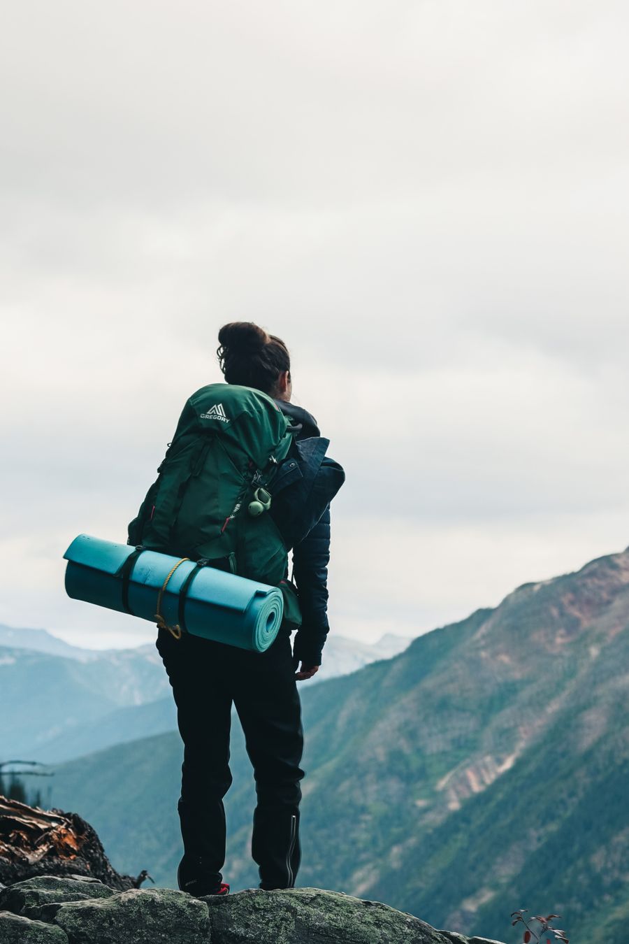 a backpacker looking at the scenery while standing on the edge of a mountain — Docs: Changelog-verlinkt: Jede Doc weiß, welches Release sie geändert hat.