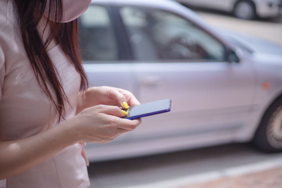 woman in pink blouse texting on a smartphone — Trailheads außerhalb von Austria: Offline-Karten geladen, für alle Fälle.