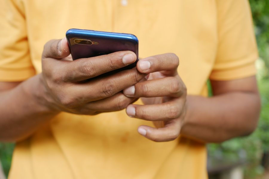 person holding blue smartphone — Innenstadt, vernetzt: Die eSIM findet von allein das schnellste lokale Netz.