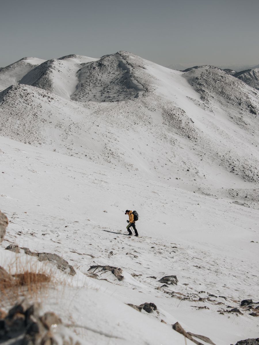 man hiking in snow in mountains — Die Foodtour: jede Empfehlung vor Ort nachgeschlagen.