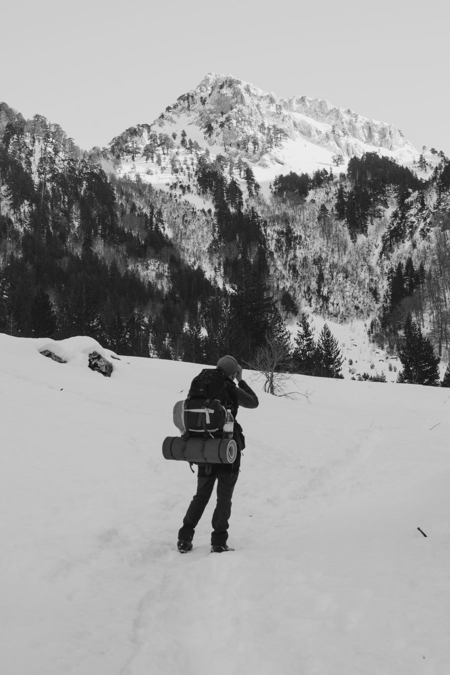 back view of a person with a backpack hiking in snowy mountains — Connection Quality Grader: answers first, never a signup wall.