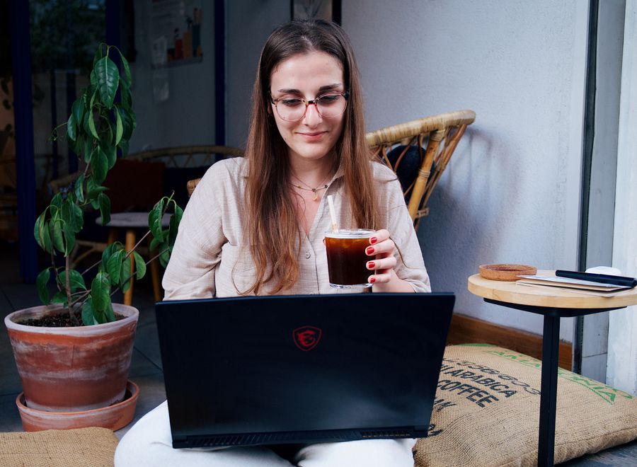 a woman sitting with a laptop — Der Austria-Bahnpass: Fahrpläne live, Sitzreservierung in der App.