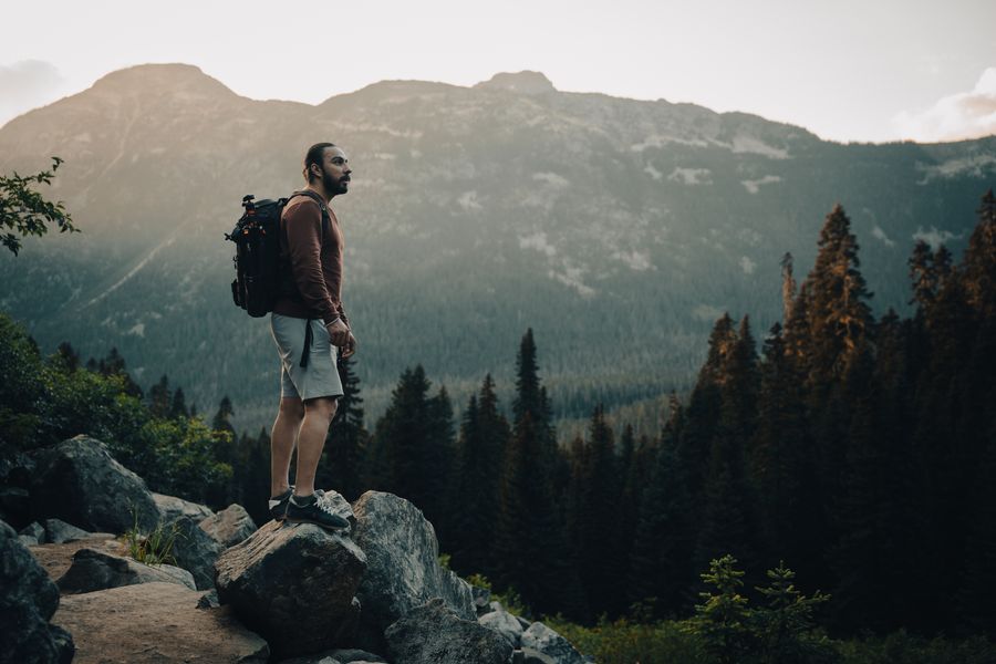 man with a backpack standing on a rock