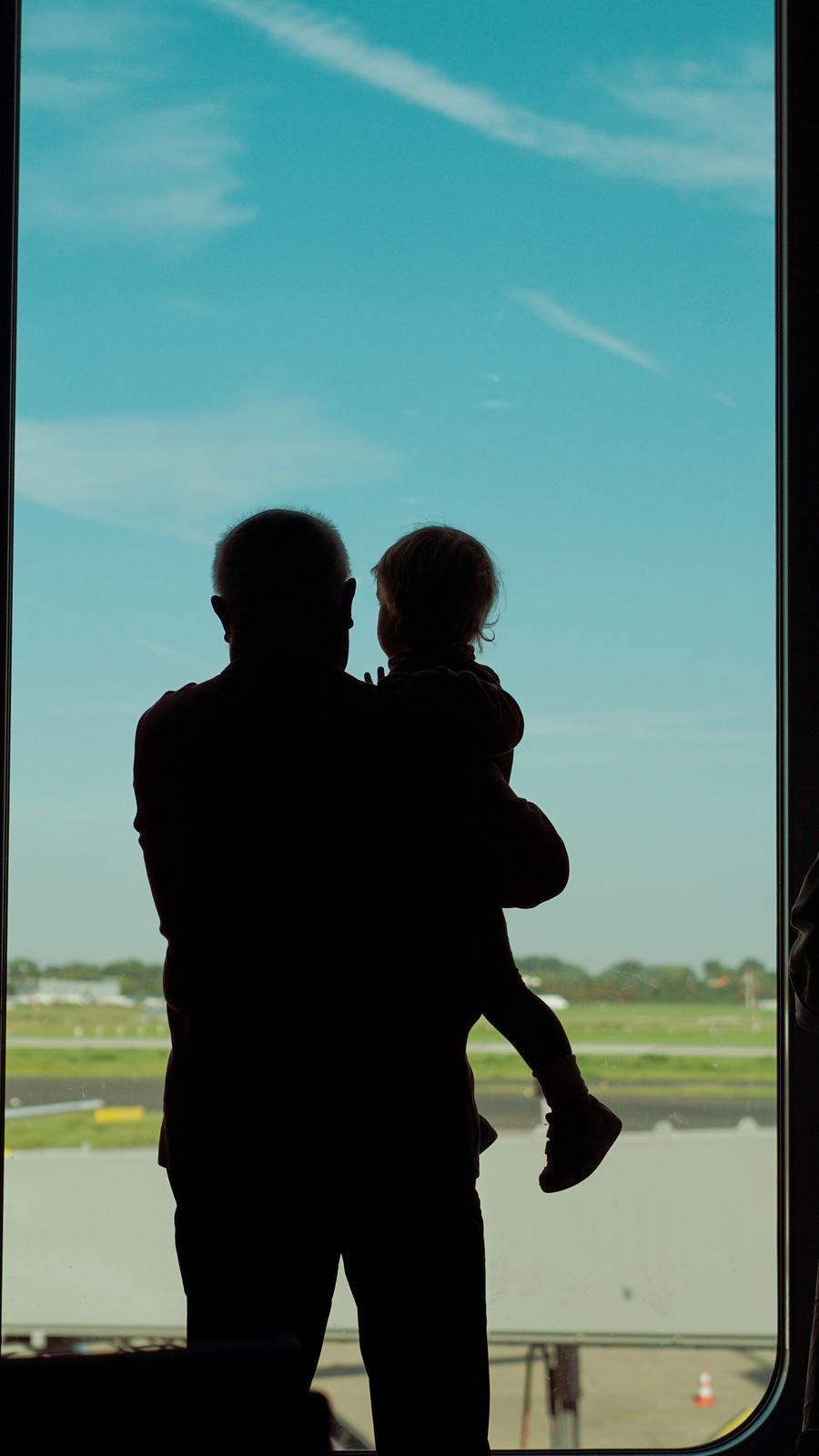 a man and child are silhouetted against an airport window — My Active eSIMs computes the moment you submit — no queues, no waiting room.
