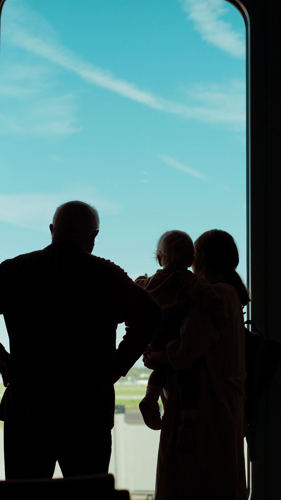 silhouette of a family looking out of a window at an airplane — Der lange Zwischenstopp: streamen, arbeiten und chatten, alles abgedeckt.