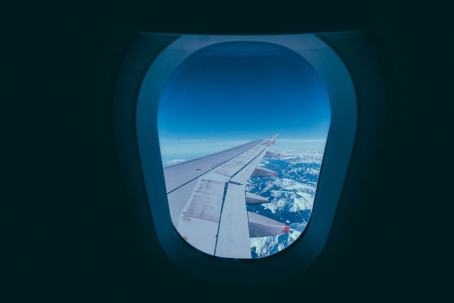 white aircraft wing — Die Austria-Skyline in der Dämmerung: Videoanruf nach Hause mit der ganzen Stadt dahinter.