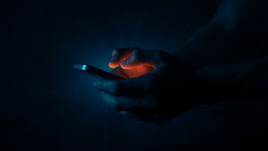 man holding a mobile phone in the dark — Changelog: Kleine Fixes shippen täglich; große bekommen einen eigenen Eintrag.