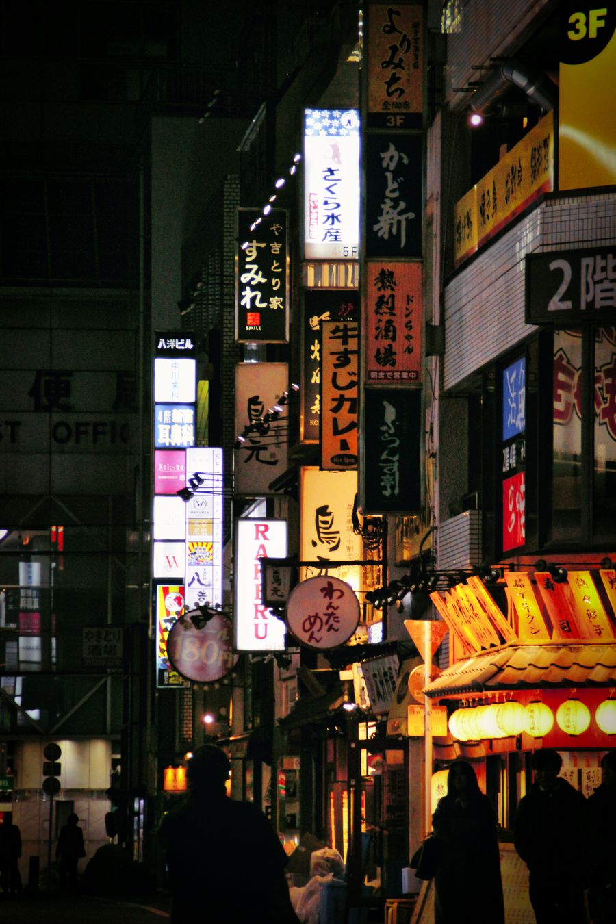 view of illuminated signs on buildings in tokyo at night — Strände von Liechtenstein: Parken per Handy bezahlt, Mittagessen vom Handtuch bestellt.