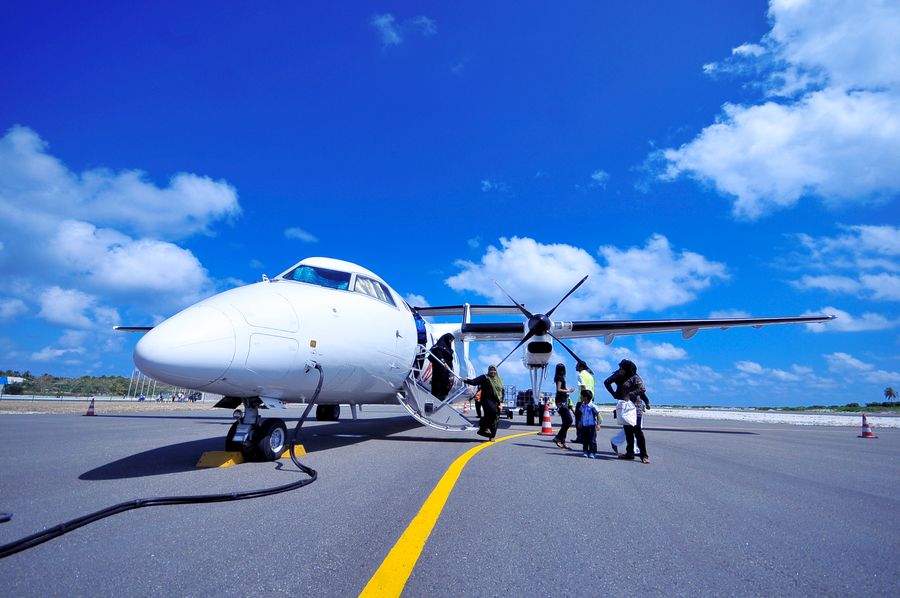 white jet on black tarmac — Harbor views with full bars: coverage where travelers actually go.