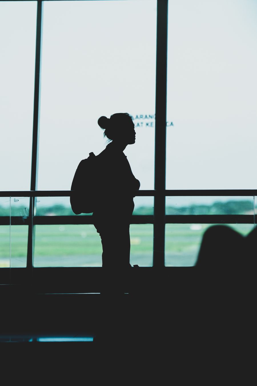 silhouette of a woman with a backpack standing at an airport terminal — Best Network by City accepts your trip details and hands back a clear recommendation.