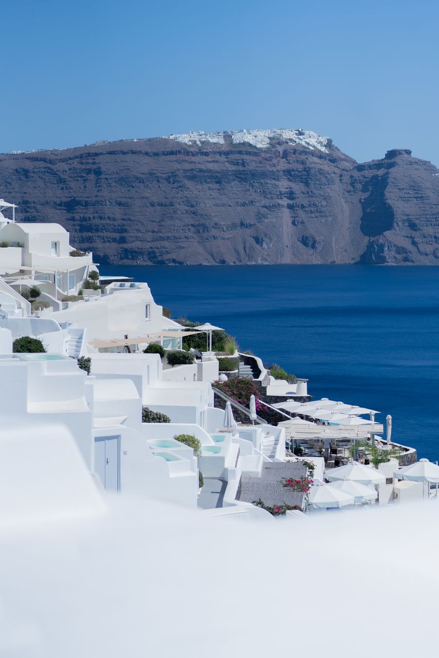 a white building with blue roof and water in the background