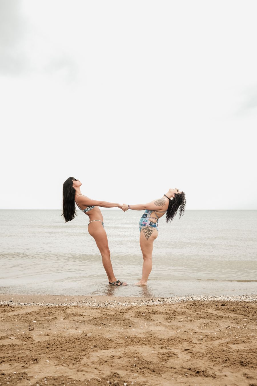 two women standing on the beach holding hands — Der Switzerland-Roadtrip: Tankstopps geplant, Playlist geladen, Karte offline.