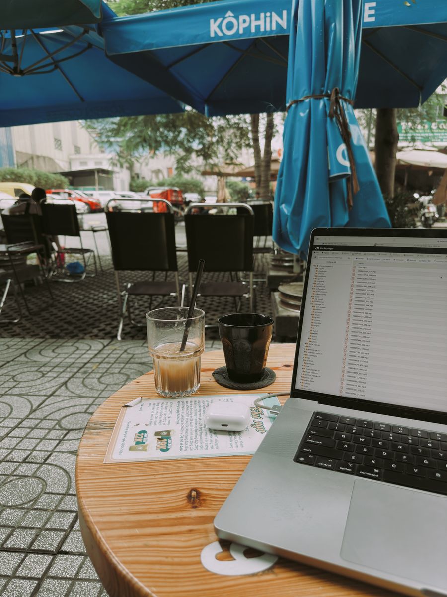 laptop and coffee at outdoor cafe workspace — Gruppenchats bleiben über jede Grenze um Austria live.