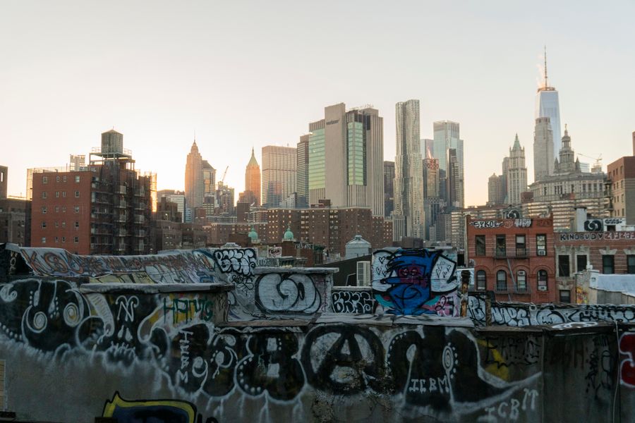 graffiti laden rooftop overlooking new york skyline — Street level: navigation, rideshares and reviews, all instant.