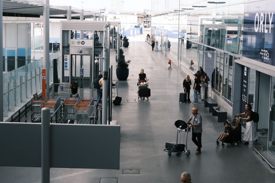 busy airport terminal with travelers and luggage — Docs: Regentag-Backupplan: Indoor-Attraktionen vom Hostelbett recherchiert.