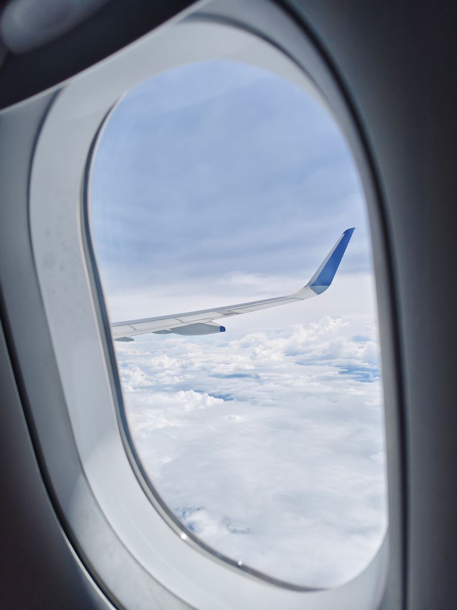 view of airplane wing and clouds from cabin