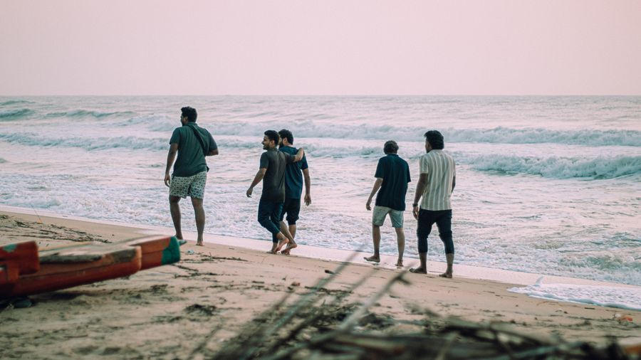 group of friends walking along beach