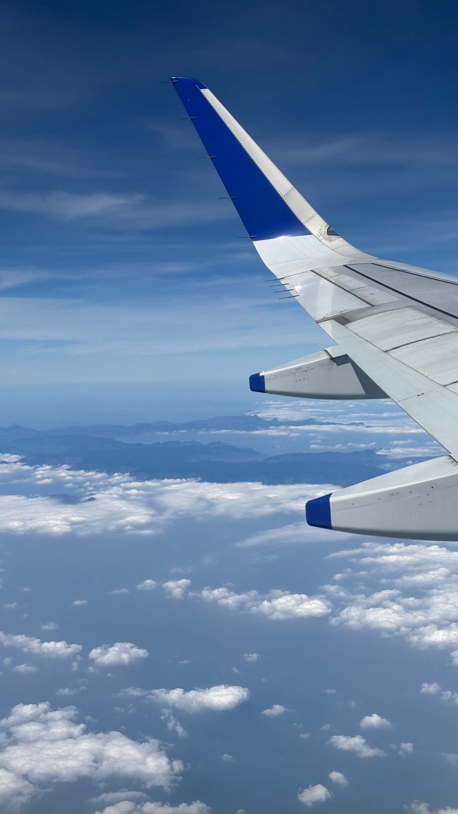 aerial view from airplane with blue wing — Real journeys, real connectivity — this is what the product is for.