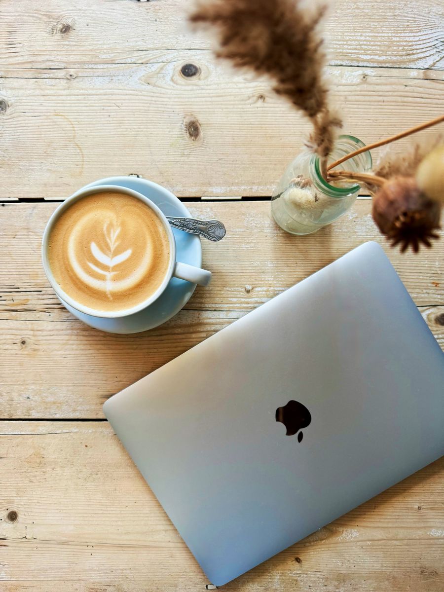 cozy cafe workspace with laptop and latte art — Changelog: Versionshistorie als Vertrauenssignal: Wir schreiben auf, was wir kaputtmachen und fixen.