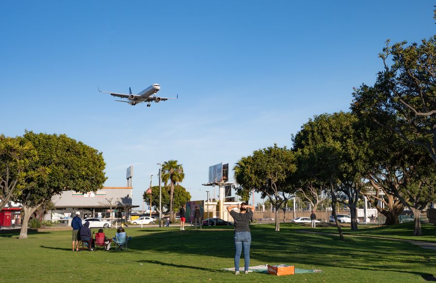 airplane landing over park visitors — Street-food stalls and mobile pay: dinner ordered without a word of the language.