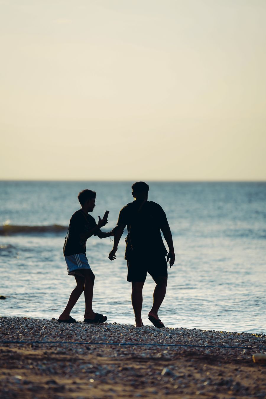silhouette of two friends enjoying a beach sunset — Coverage Checker remembers, so repeat travelers barely type.