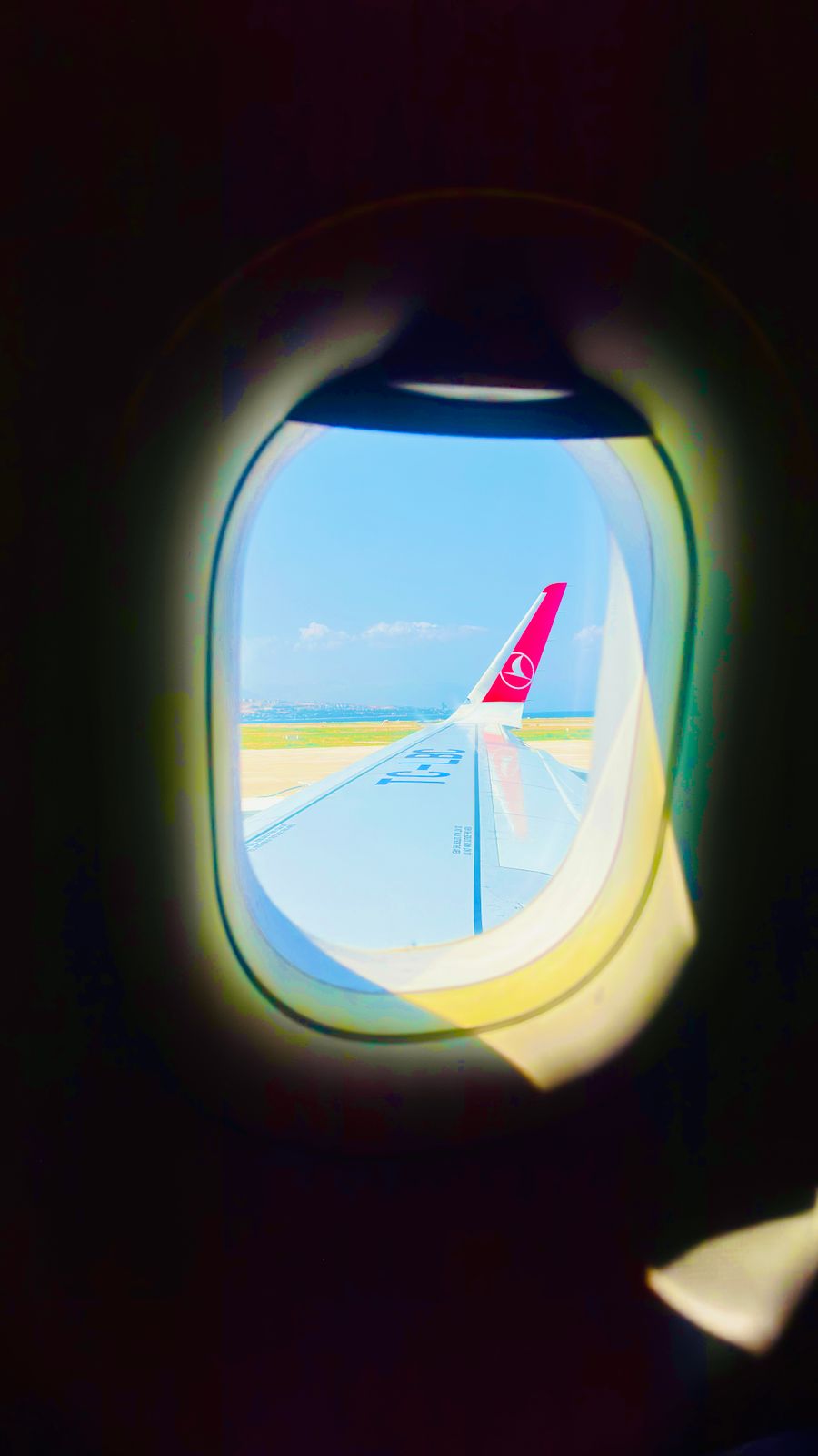 view from airplane window over turquoise skies — Support: Die Foodtour: jede Empfehlung vor Ort nachgeschlagen.