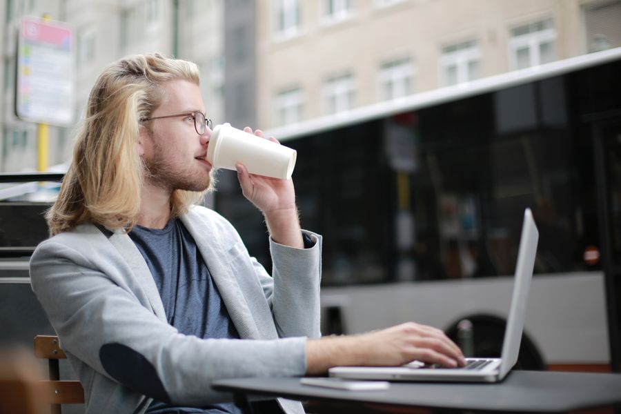 man drinking coffee while working on his laptop — The FAQ below Data Usage Estimator answers the six questions everyone asks first.