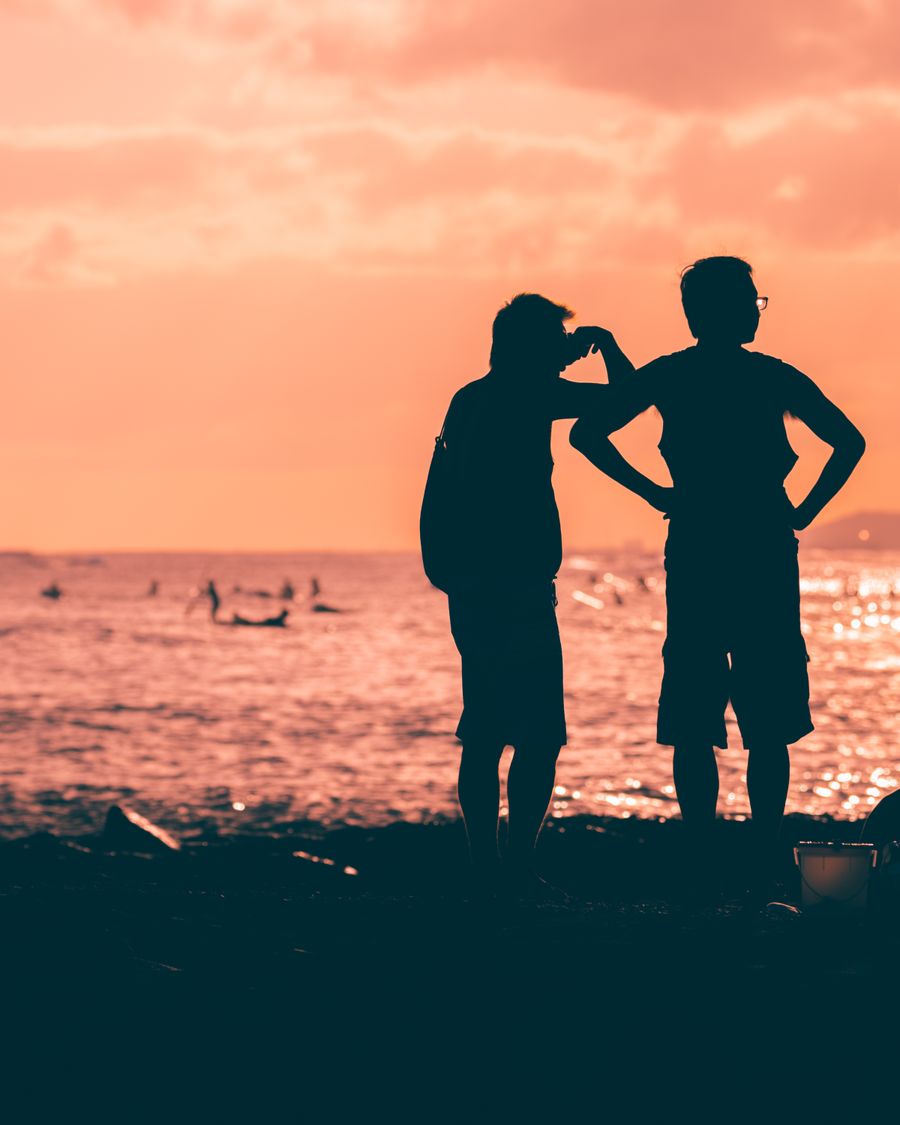 silhouette of 2 men and woman standing on beach during sunset — Der Liechtenstein-Zwischenstopp: arbeiten, streamen und chatten, alles abgedeckt.