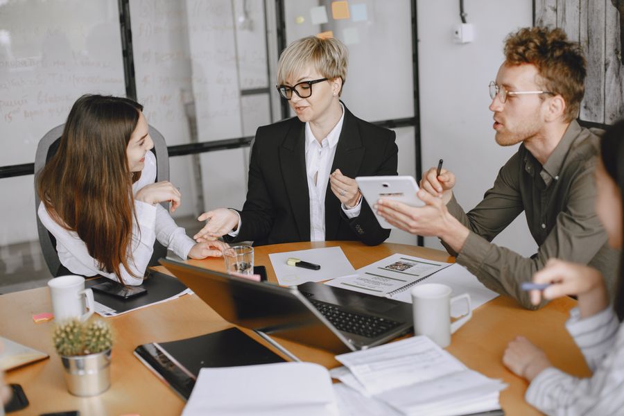 businesspeople brainstorming in conference room — Docs: Jede Doc endet mit „noch festgefahren?“ — zeigend auf den Tele Agent.