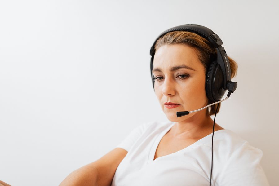 woman wearing a black headset — Der Agent liest dieselben Live-Daten wie die Tools — eine einzige Wahrheit.