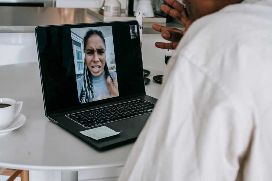 unrecognizable ethnic man having video conference with upset girlfriend — eSIM Troubleshooter links every answer onward — usually the plan it recommends.