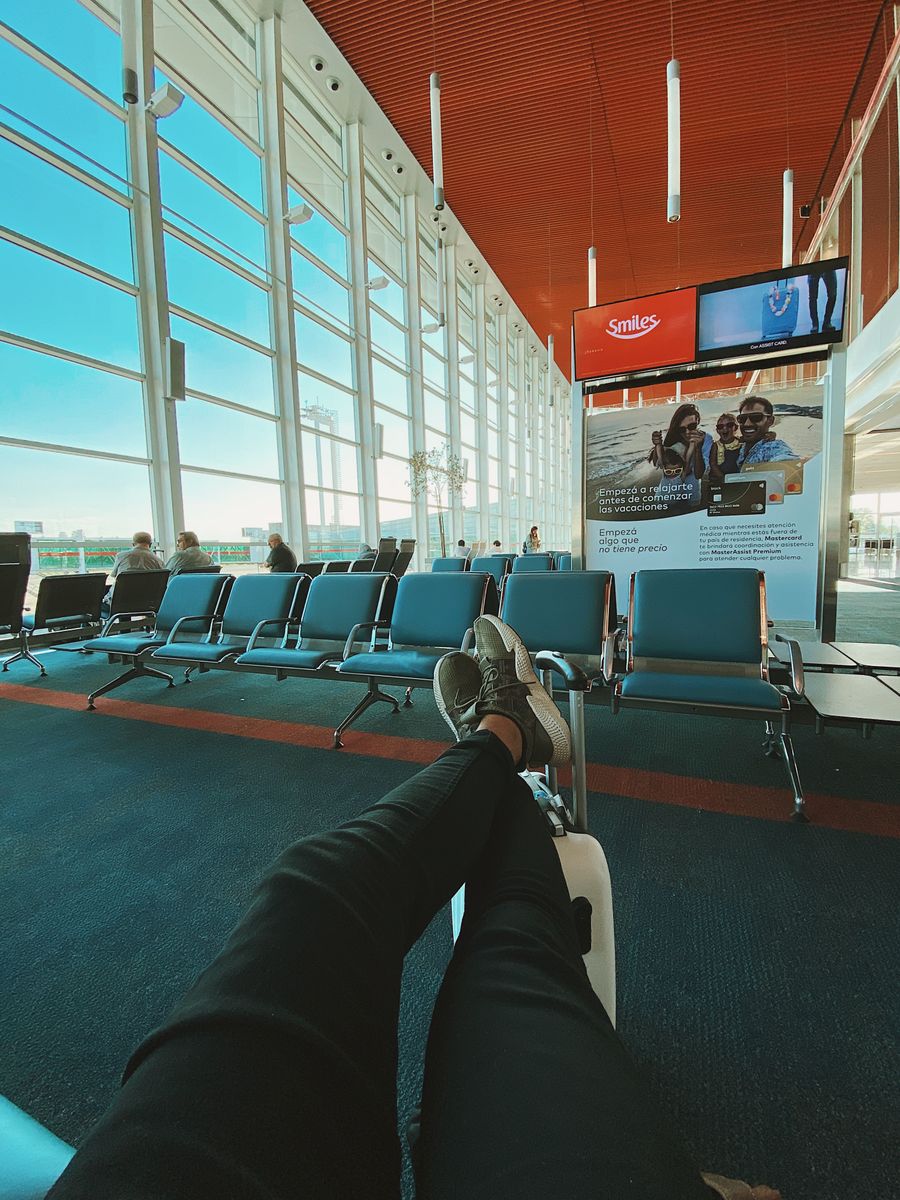 man waiting for flight in airport — Developers: Innenstadt, vernetzt: Die eSIM findet von allein das schnellste lokale Netz.