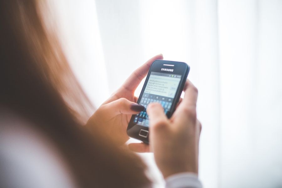 girl using mobile phone — Die Abflugtafel springt um: Gate gefunden, Lounge lokalisiert, alles auf der eSIM.