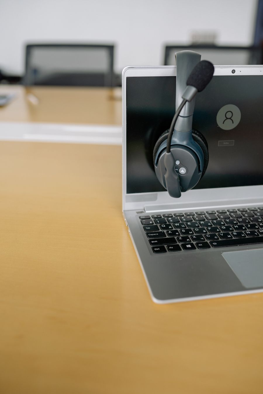 close up shot of a headset on a laptop — Die COUNTRY-Skyline in der Dämmerung: Videoanruf nach Hause mit der ganzen Stadt dahinter.