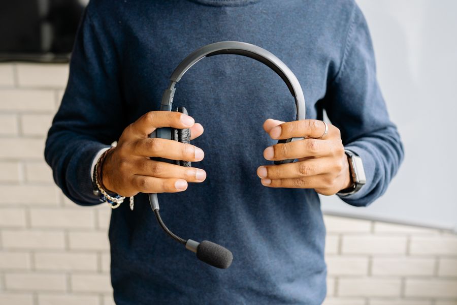 a person holding a headset — Der Tele Agent: die Support-Seite, die zurückspricht.