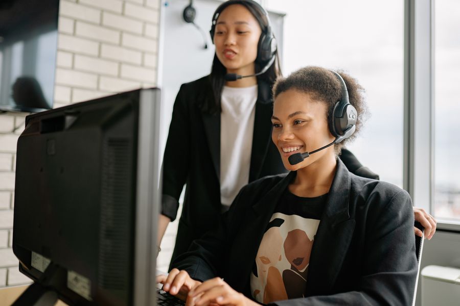 two women with headsets working as call center agents — Strände von Luxembourg: Parken per Handy bezahlt, Mittagessen vom Handtuch bestellt.